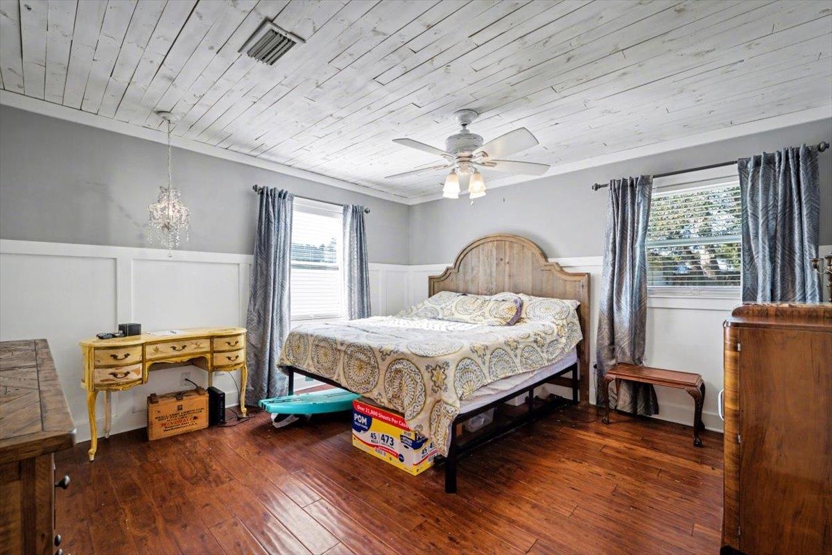 979 Altara Avenue St. Augustine, FL 32086 - Photo 11 of 27 a bedroom with a bed a flat screen tv and a large window with wooden floor