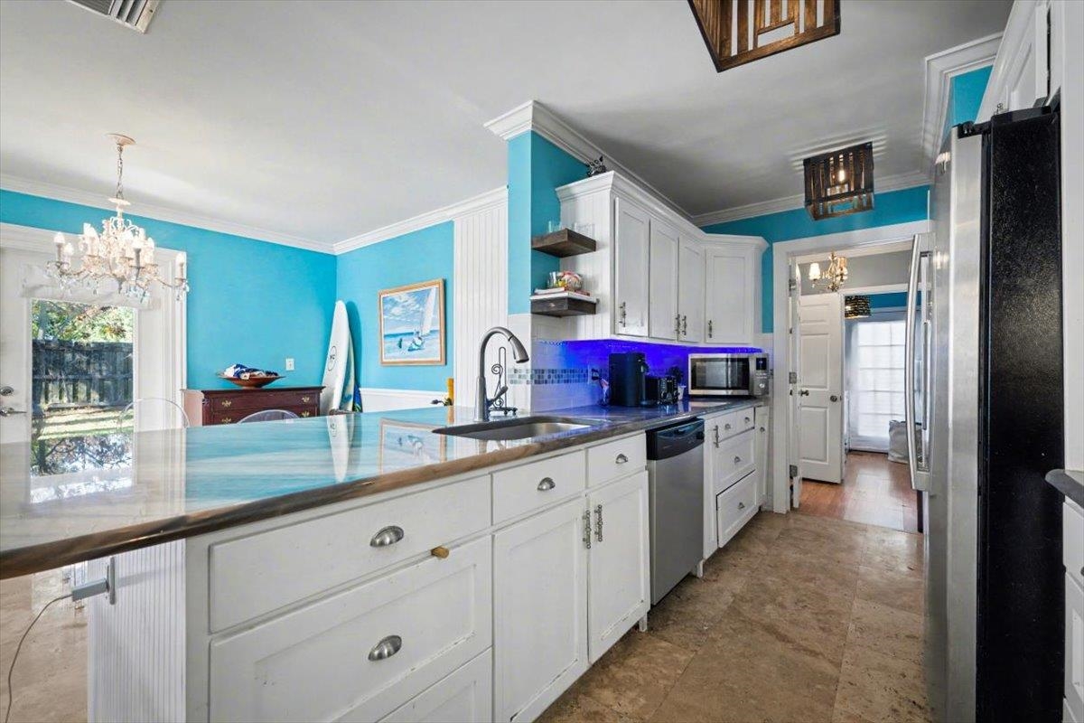979 Altara Avenue St. Augustine, FL 32086 - Photo 6 of 27 a large kitchen with granite countertop a sink and white cabinets