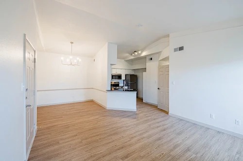 11908 Anderson Mill Road, Unit 421 Cedar Park, TX 78613 - Photo 12 of 21 an empty room with wooden floor and a kitchen