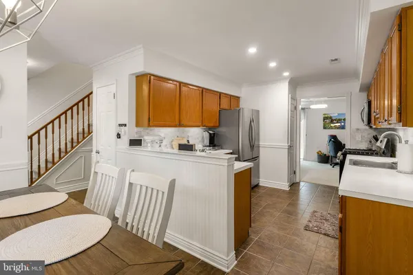 a kitchen with stainless steel appliances granite countertop a refrigerator a sink dishwasher a stove with wooden cabinets and floor