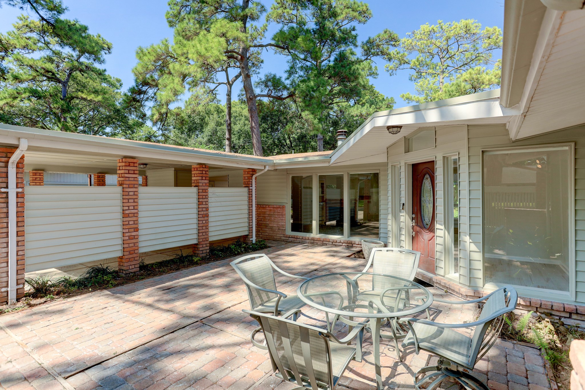 10226 Ivyridge Road Houston, TX 77043 - Photo 3 of 37 a view of a patio with table and chairs with wooden fence and plants