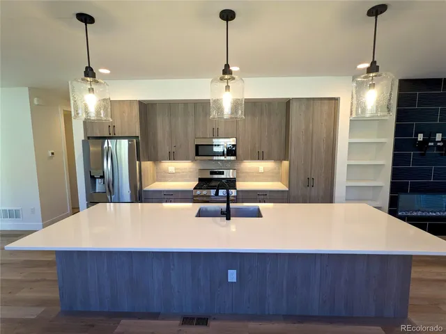 a kitchen with kitchen island a counter top space appliances and cabinets