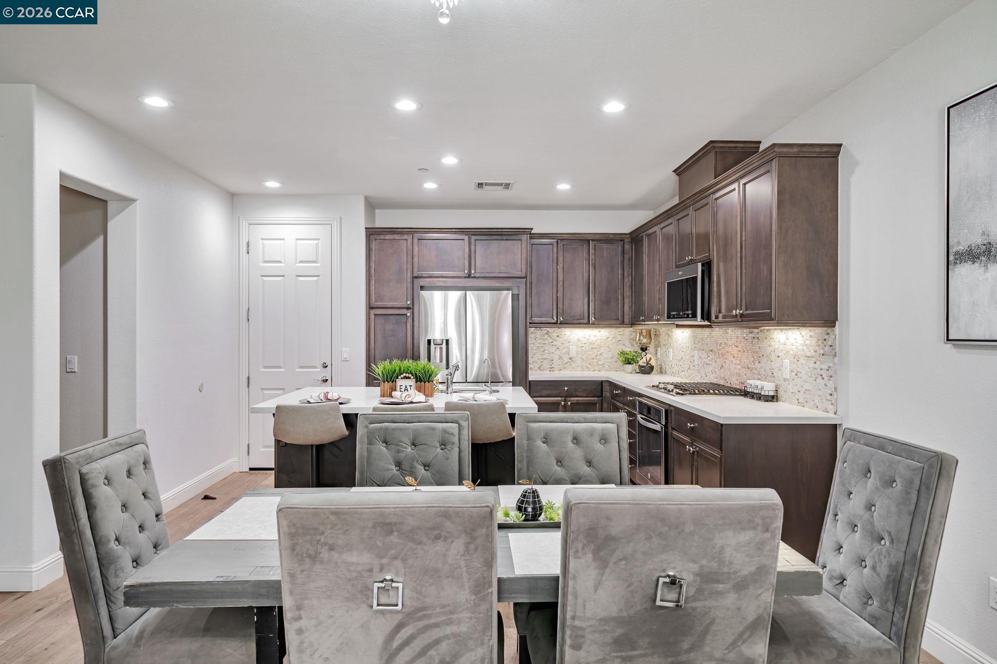 6260 Main Branch Road San Ramon, CA 94582 - Photo 14 of 38 a kitchen with stainless steel appliances granite countertop a stove a sink a refrigerator white cabinets and couches with wooden floor