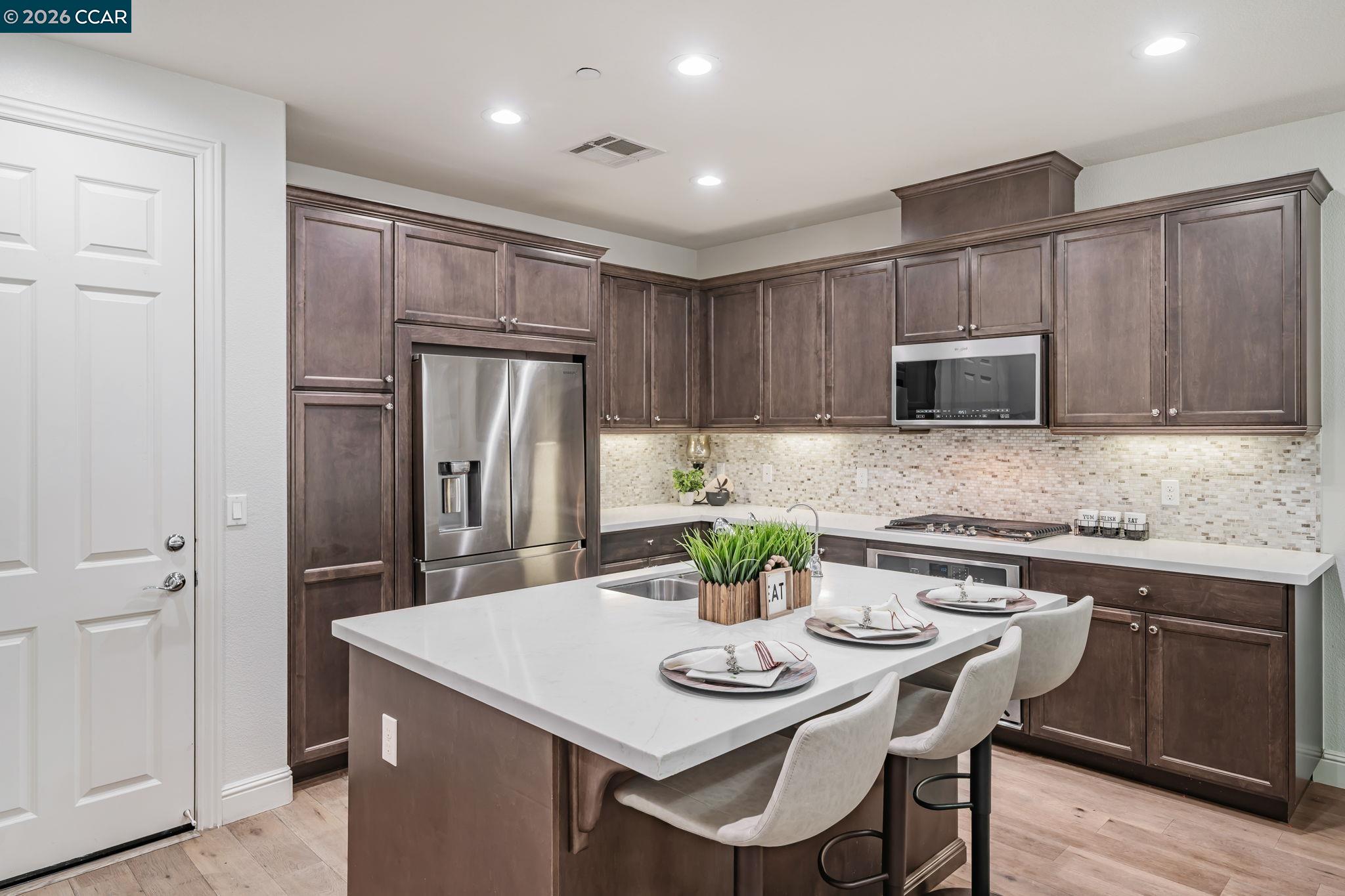 6260 Main Branch Road San Ramon, CA 94582 - Photo 10 of 38 a kitchen with stainless steel appliances granite countertop a kitchen island a stove a table and chairs