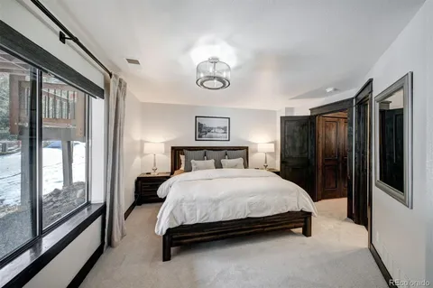 a bedroom with a large bed and a chandelier