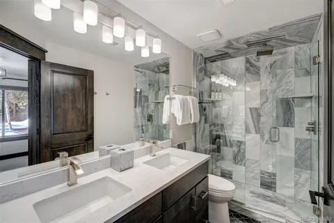 a bathroom with a sink a toilet and shower