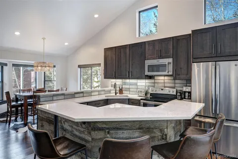 a kitchen with a table chairs stove and cabinets