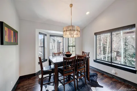 a dining room with furniture a chandelier and wooden floor