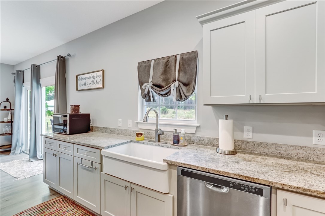 56049 Griffin Road Callahan, FL 32011 - Photo 14 of 30 a kitchen with stainless steel appliances granite countertop a sink and a white cabinets
