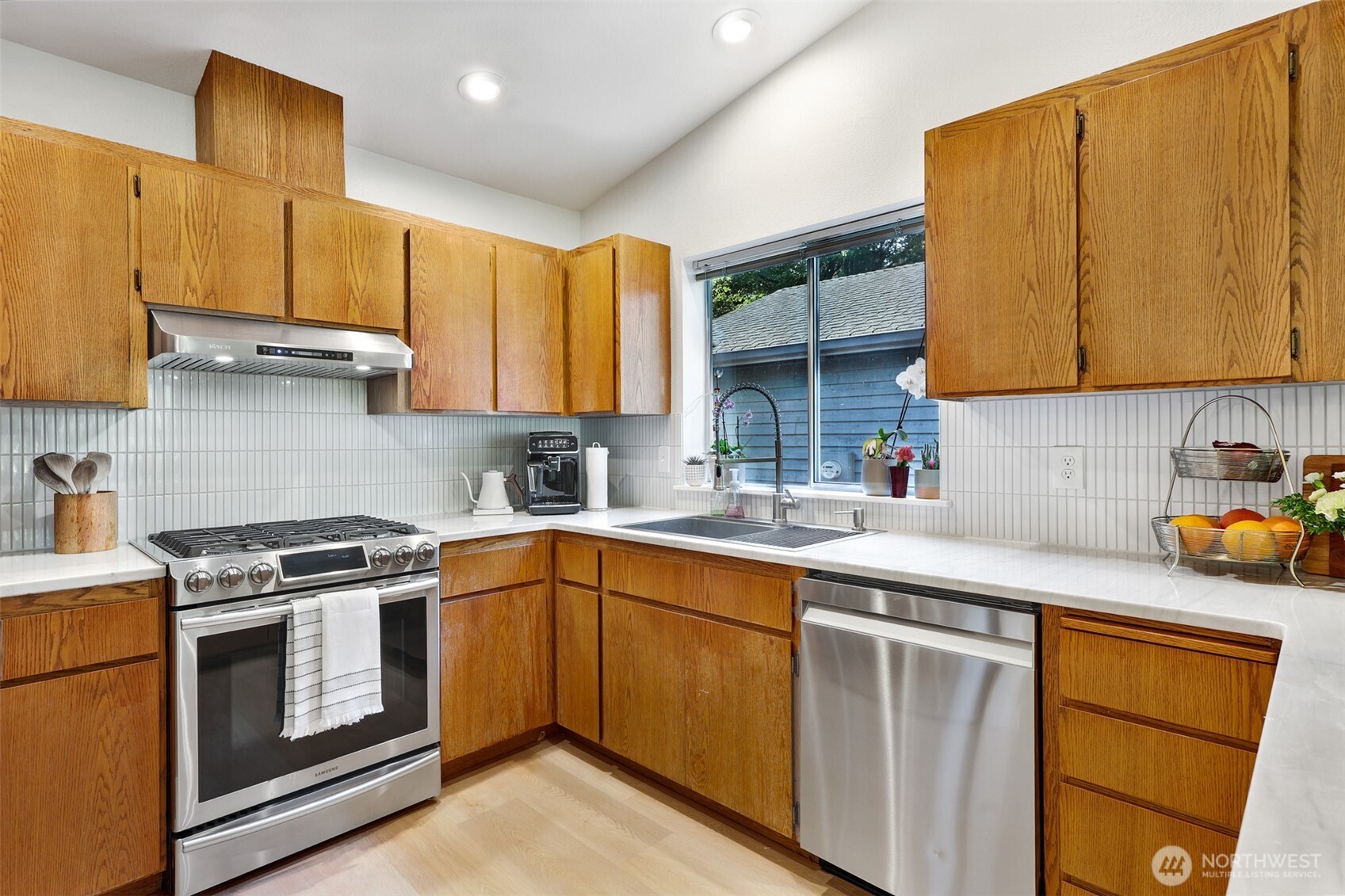 5126 South Garden Loop Road, Unit 11 Seattle, WA 98118 - Photo 13 of 36 a kitchen with stainless steel appliances granite countertop a sink a stove and a refrigerator