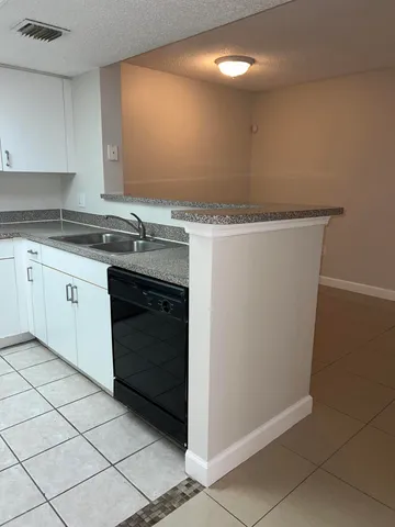 a kitchen with granite countertop a sink and a stove