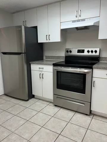 a kitchen with cabinets and steel stainless steel appliances