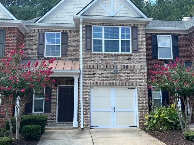 a front view of a house with a garden and plants
