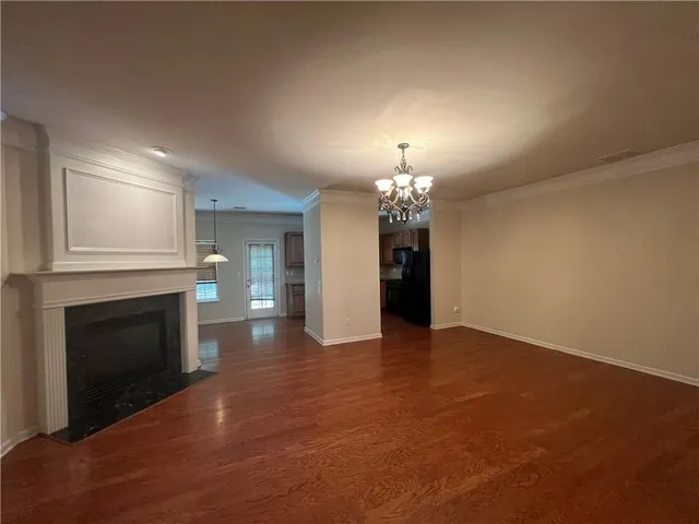 an empty room with fireplace and chandelier