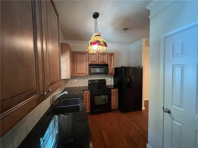 a kitchen with stainless steel appliances granite countertop a refrigerator and a stove