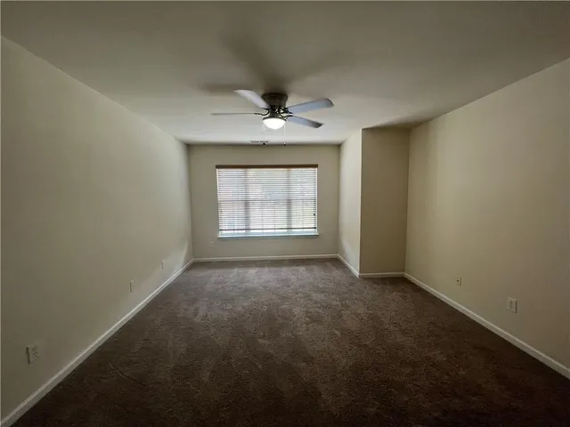 an empty room with a window and a ceiling fan