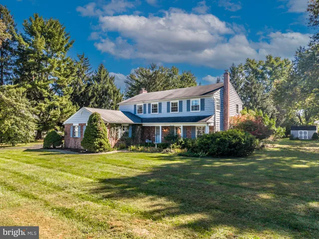 a view of a house with a big yard and palm trees