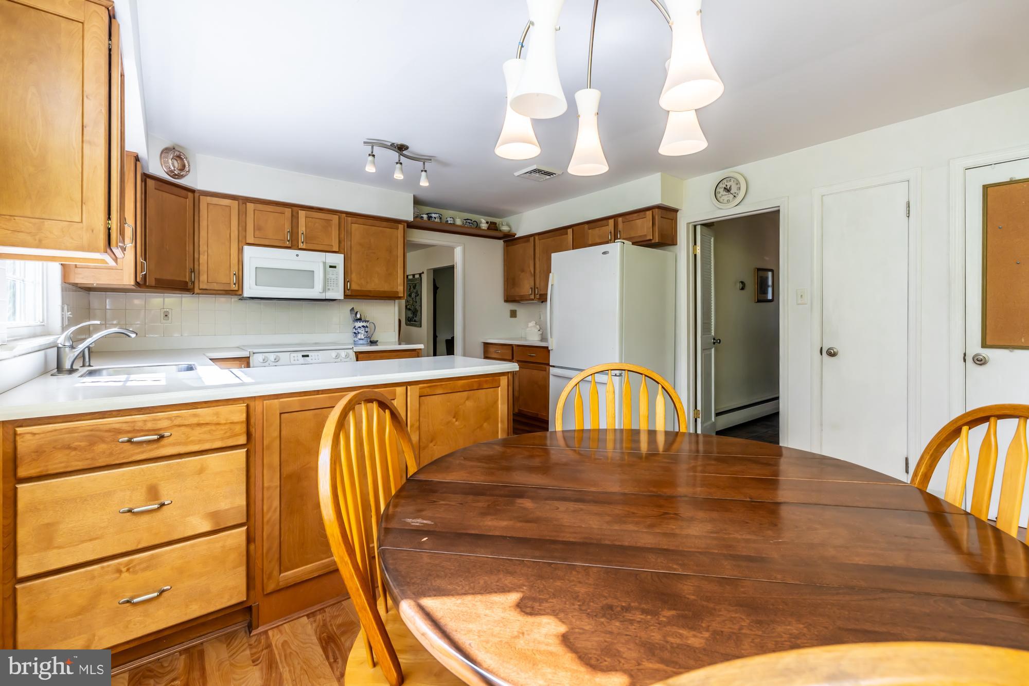 12 Flintshire Road Malvern, PA 19355 - Photo 18 of 50 a view of a kitchen with a sink dishwasher a dining table and chairs with wooden floor