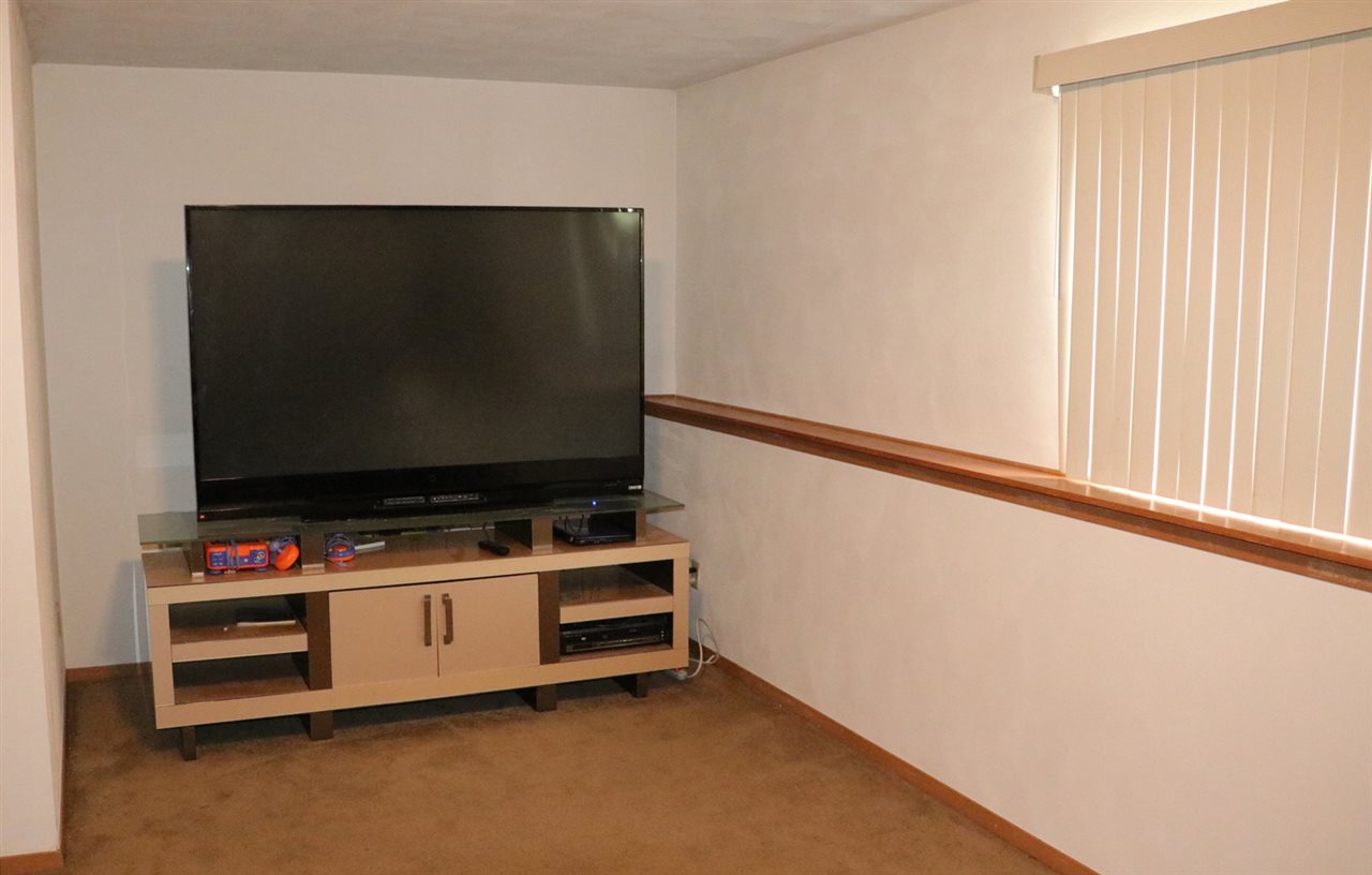 3950 Linden Road Rockford, IL 61109 - Photo 6 of 12 a room with furniture and flat screen tv