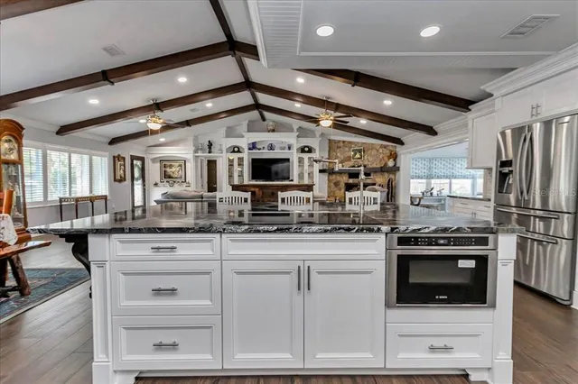 a bedroom with a large bed a flat tv screen and a chandelier