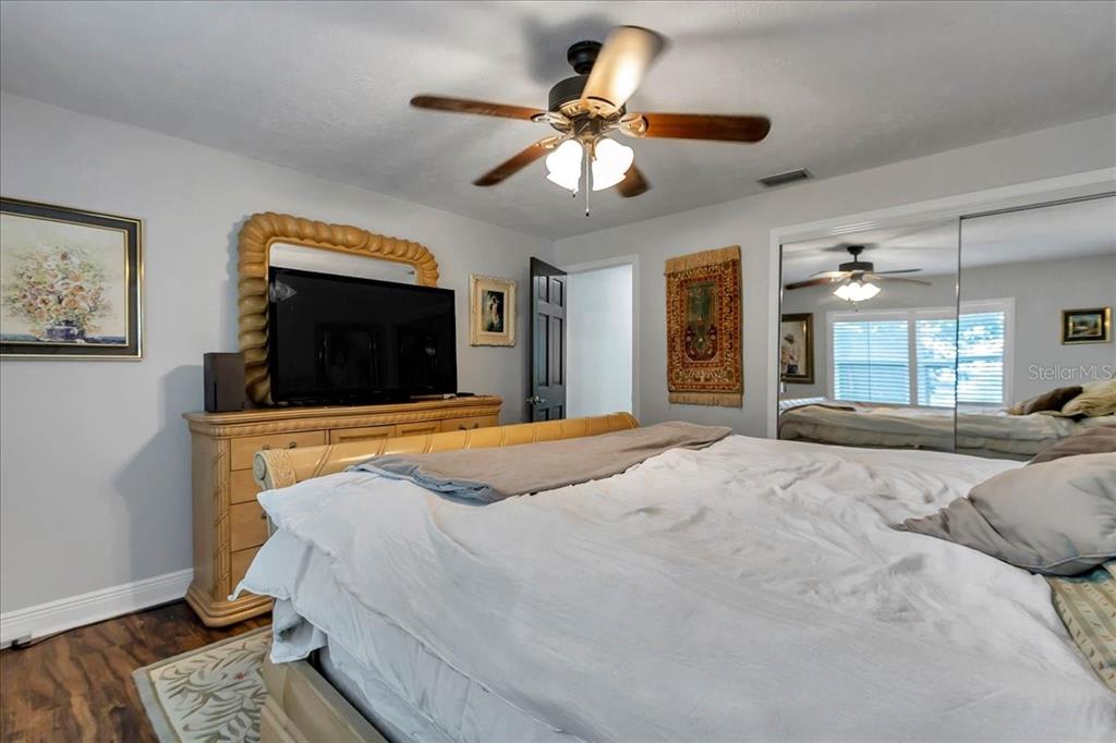 223 South Nesbitt Terrace Inverness, FL 34450 - Photo 35 of 85 a bedroom with a large bed a flat tv screen and a chandelier