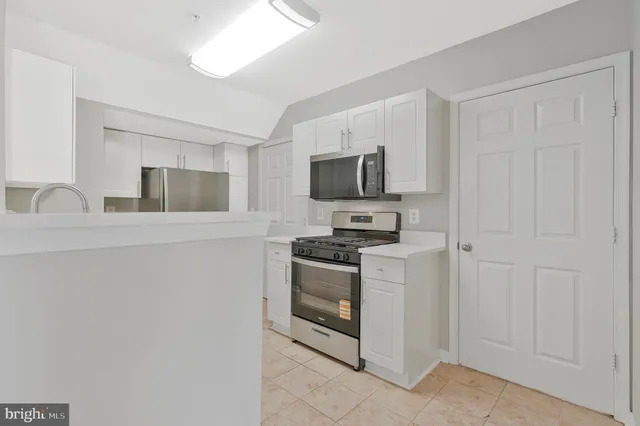 a kitchen with stainless steel appliances granite countertop a sink stove a refrigerator and microwave