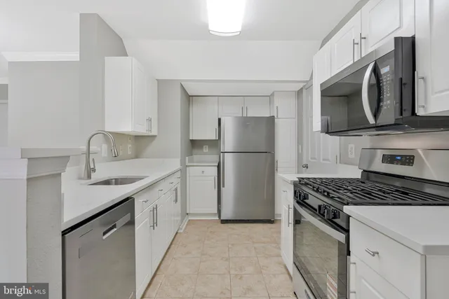 a kitchen with stainless steel appliances granite countertop a stove microwave and refrigerator