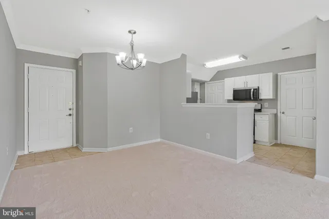 a view of a big room with windows and chandelier fan