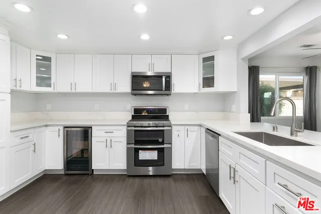 a kitchen with stainless steel appliances a stove sink microwave and cabinets