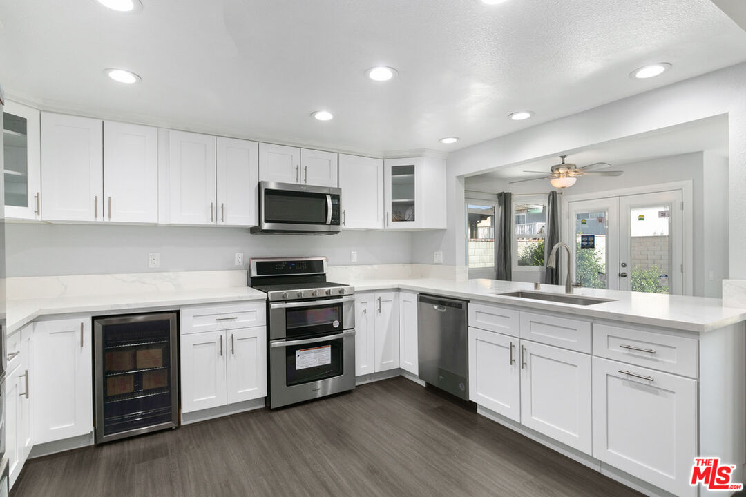 6703 Poinsettia Court Chino, CA 91710 - Photo 3 of 36 a kitchen with white cabinets and stainless steel appliances