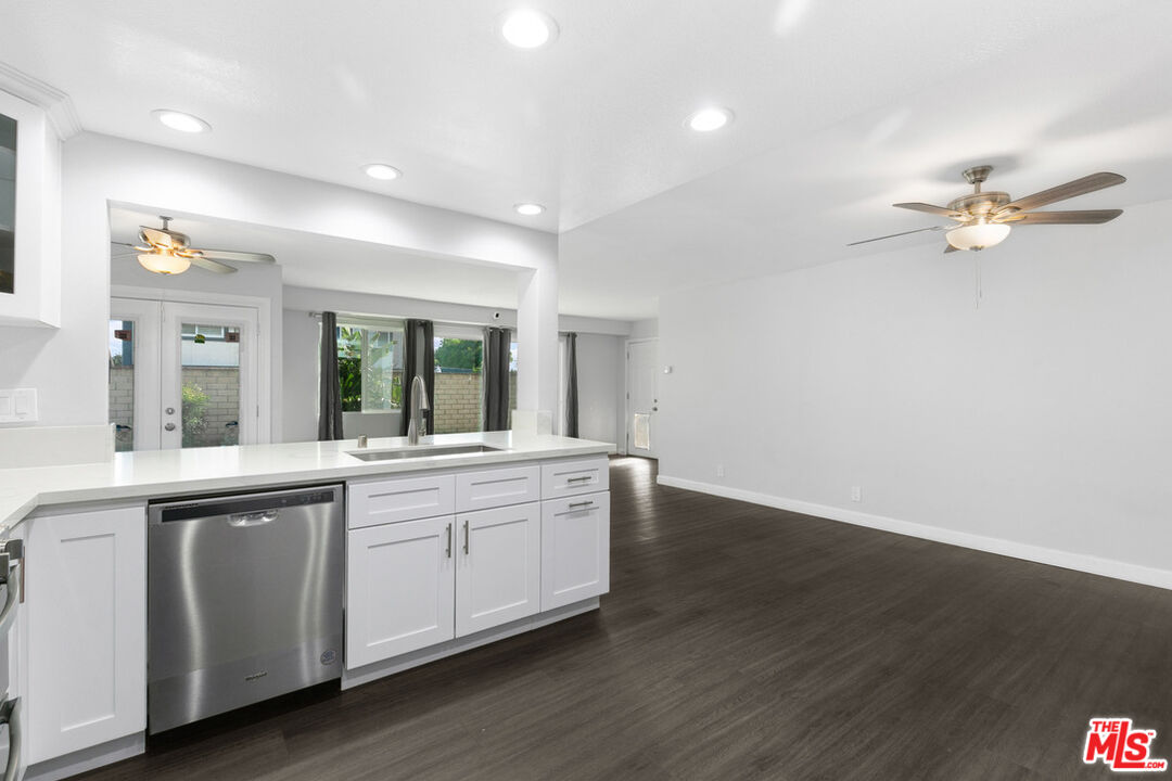 6703 Poinsettia Court Chino, CA 91710 - Photo 6 of 36 a large white kitchen with sink and dishwasher with wooden floor