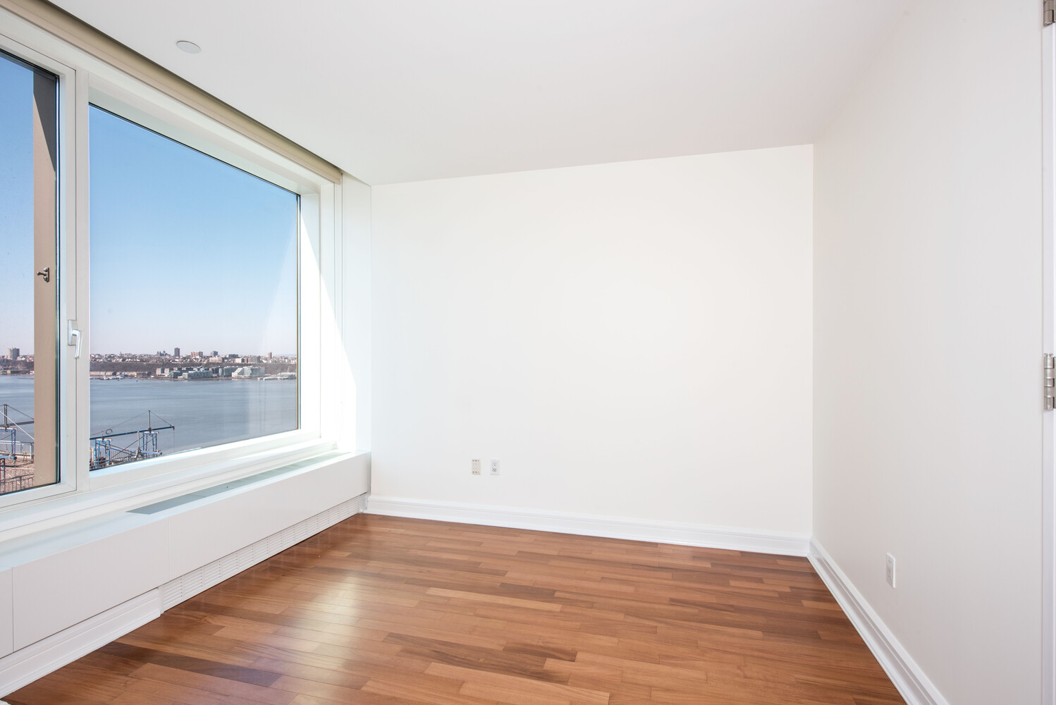 240 Riverside Boulevard, Unit 22BC Manhattan, NY 10069 - Photo 10 of 17 a view of a small space with wooden floor and a window