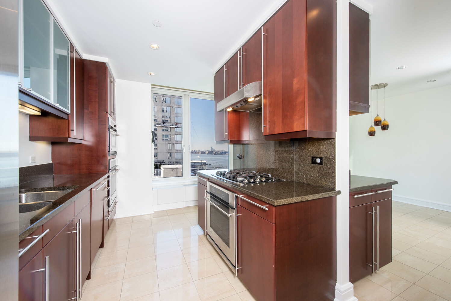 240 Riverside Boulevard, Unit 22BC Manhattan, NY 10069 - Photo 4 of 17 a kitchen with stainless steel appliances granite countertop a stove a sink and a refrigerator