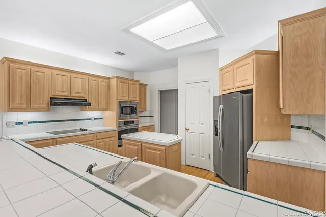 a kitchen with a sink stove top oven and refrigerator