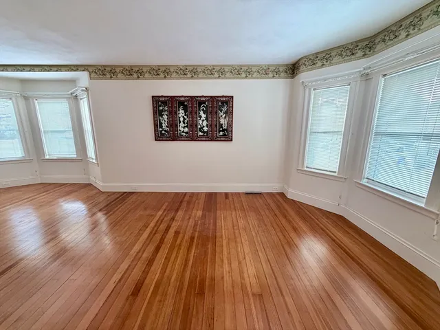 a view of a room with wooden floor and window