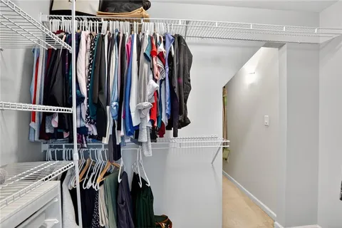 a view of walk in closet with clothes and shoes