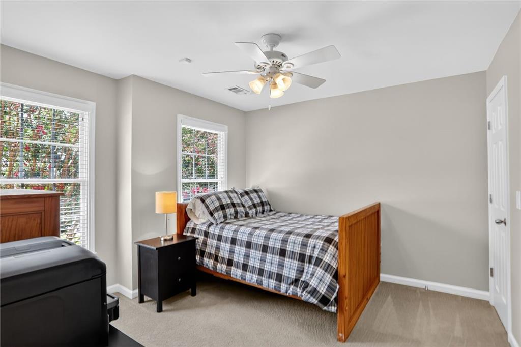 4760 Fontwell Court Suwanee, GA 30024 - Photo 21 of 43 a bedroom with a bed and a chandelier