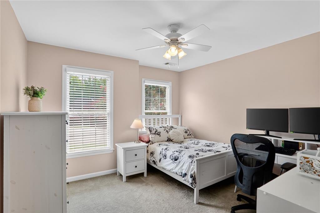 4760 Fontwell Court Suwanee, GA 30024 - Photo 22 of 43 a bedroom with a bed and a chandelier