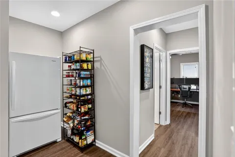 a view of a hallway with wooden floor and workspace