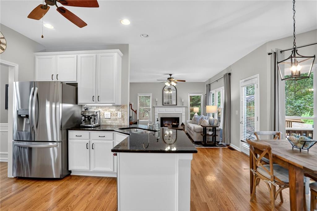 4760 Fontwell Court Suwanee, GA 30024 - Photo 5 of 43 a kitchen with stainless steel appliances granite countertop a sink refrigerator stove and wooden floor