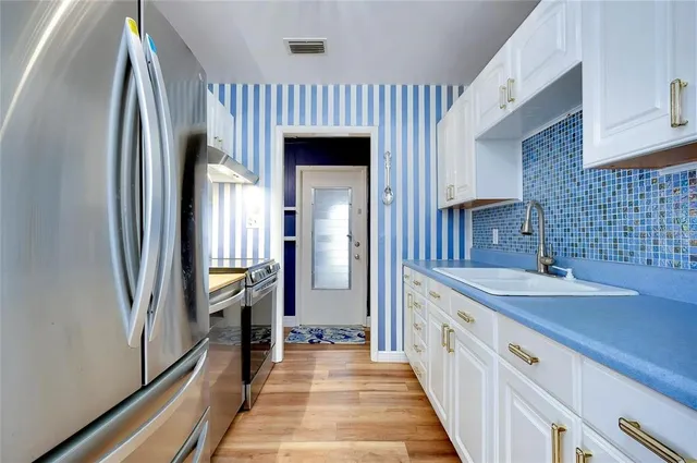a kitchen with stainless steel appliances granite countertop a refrigerator and a sink
