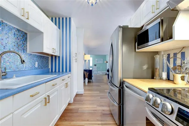 a view of a kitchen with kitchen island a sink a stove and a refrigerator