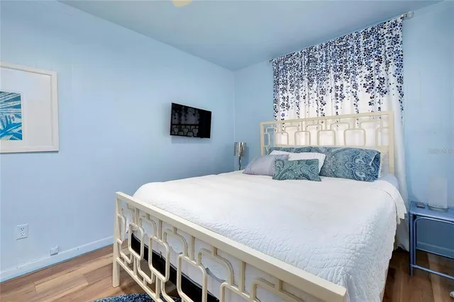 a bedroom with a bed a flat screen tv and a window