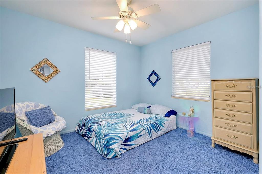 6560 Marius Road North Port, FL 34287 - Photo 10 of 35 a bedroom with a bed and a chandelier