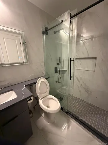 a bathroom with a granite countertop toilet sink and shower