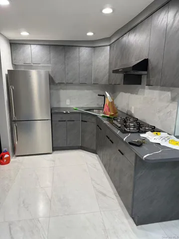 a kitchen with stainless steel appliances granite countertop a refrigerator a sink and a stove