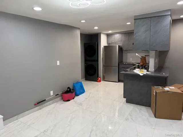 a kitchen with stainless steel appliances kitchen island granite countertop a refrigerator a stove and a sink