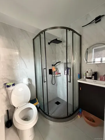 a bathroom with a granite countertop toilet and a sink