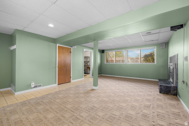 2088 Falcon Way Sandy, UT 84093 - Photo 29 of 46 Spacious room featuring patterned carpet, light green walls, a black stone fireplace, and multiple windows