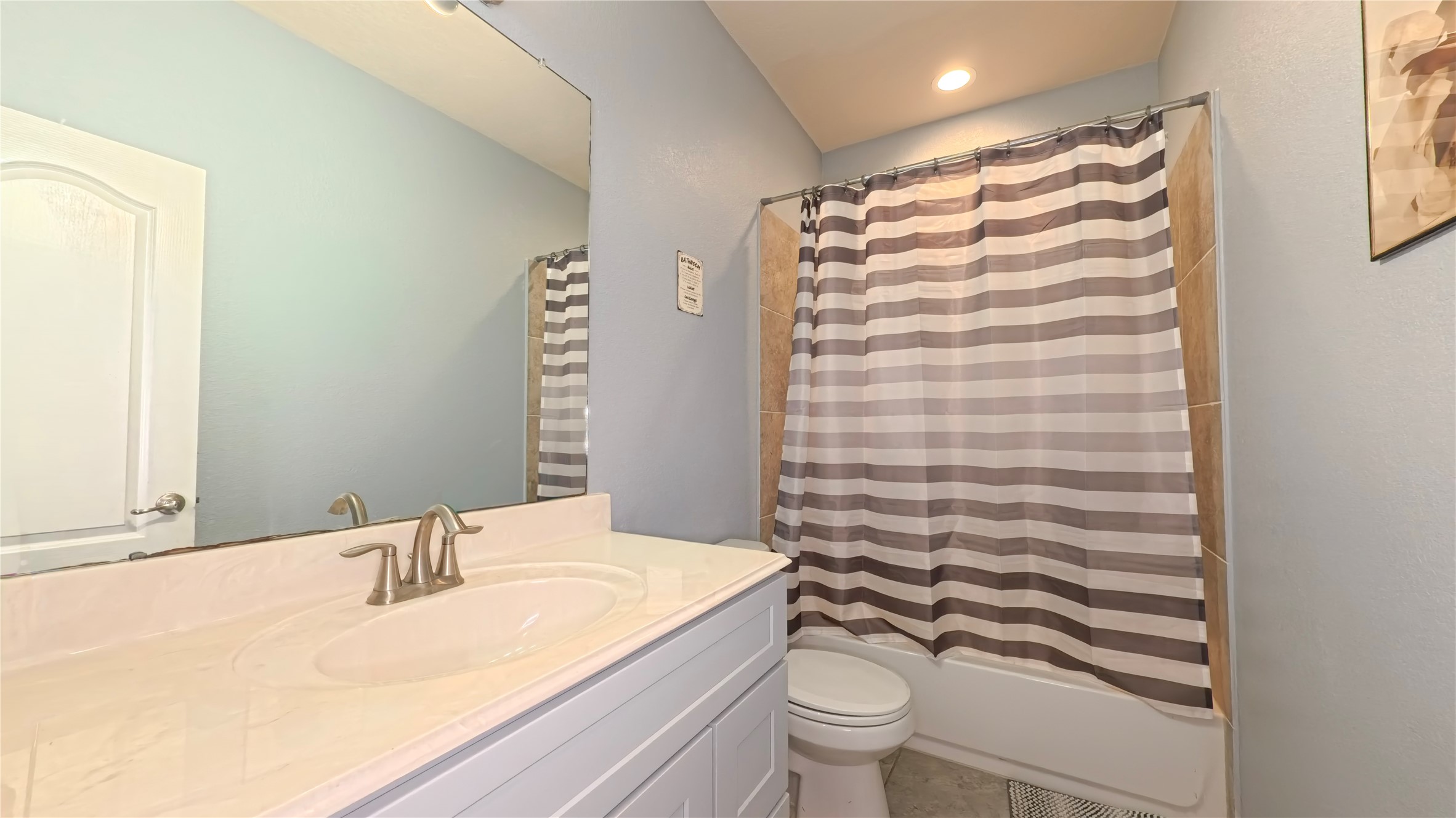 9707 Shimmering Lakes Drive Rosharon, TX 77583 - Photo 14 of 19 a bathroom with a granite countertop sink a toilet and shower curtain